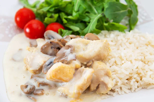 Pieces of chicken fillet cooked in a cream sauce with mushrooms and lemon juice, served with rice.
