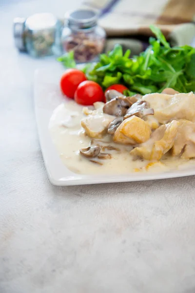 Pieces of chicken fillet cooked in a cream sauce with mushrooms and lemon juice, served with rice.