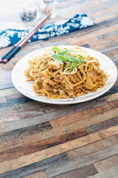 Pad Thai, vegan recipe made with rice noodles, vegetables and peanuts cooked on wo