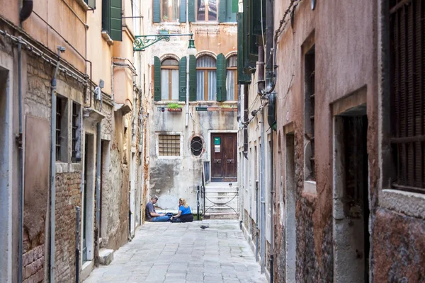 Туристи відпочивають на вузькій вулиці - Венеція (Італія). — стокове фото