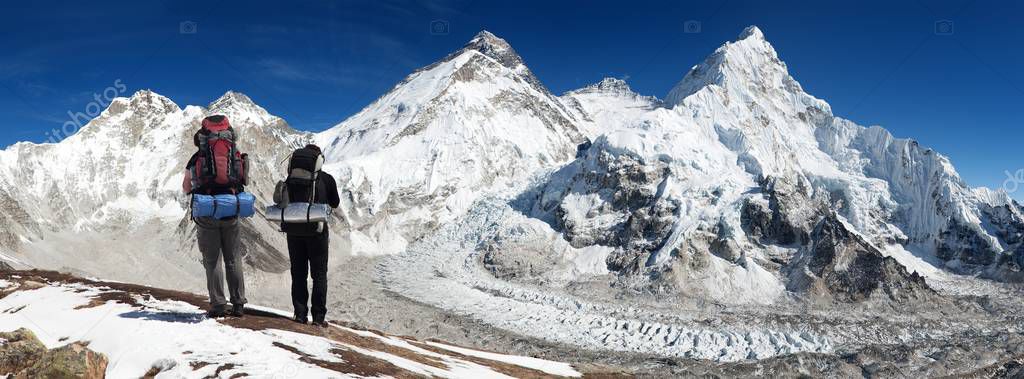 Panoramic view of Mount Everest from Pumo Ri base camp with two tourists on the way to Everest base camp, Sagarmatha national park, Khumbu valley - Nepal Himalayas mountains