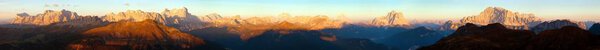 Evening sunset colored panoramic view of Alps Dolomites mountains from Col di Lana, Civetta, Pelmo, Tofana, Fanes, Cristallo, Antelao and others, Italian dolomites, Italy