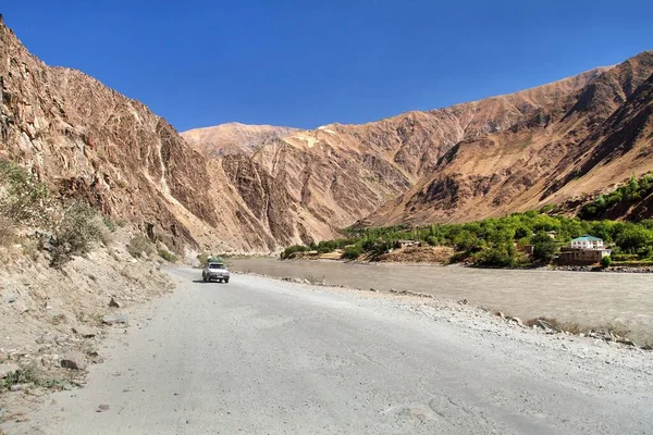 Pamir otoyolu M41 uluslararası karayolu veya Pamirskij trakt ve araba. Panj Nehri ve Pamir Dağları. Panj, Amu Darya nehrinin üst kısmıdır. Panoramik manzara. Tacikistan ve Afganistan sınırı