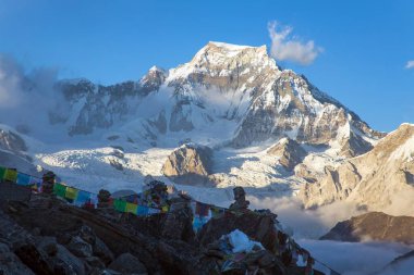 Gokyo Ri tepesinden Gyachung kang Dağı ve Budist namaz bayrakları akşam gün batımı manzarası, Everest alanı, Sagarmatha milli parkı, Gokyo vadisi, Khumbu vadisi, Nepal Himalayas dağları
