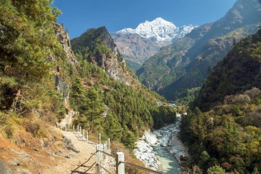 Dudh Koshi nehri kanyonu Lukla ve Namche Çarşısı arasında, Khumbu vadisinde Himalaya yamaçlarında yürüyüş yolu ve Thamserku dağı, Everest ana kampı Nepal Himalayas dağları arasında.