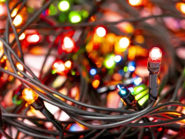 Christmas garland. Closeup of a red light bulb. Black wire