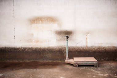 Eski büyük paslı ağırlığında ambar grungy duvarda yanında arka plan olarak ölçeklendirir