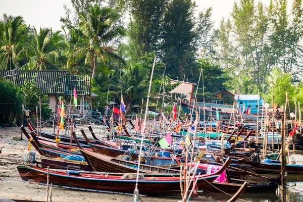 Traditional south-east asian Wooden Fishing Boats Docking At the beach near the village With Palm trees as a Background.