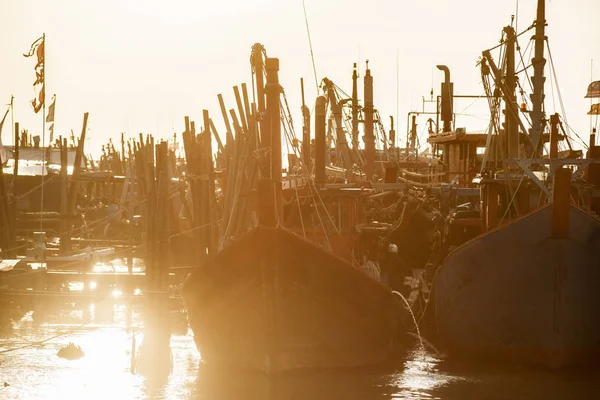 Traditional south-east asian Wooden Fishing Boats Docking  in rays of the morning sun