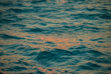 Dalgalar ve gündoğumu sırasında su yüzeyinde ripples. mavi ve turuncu renk