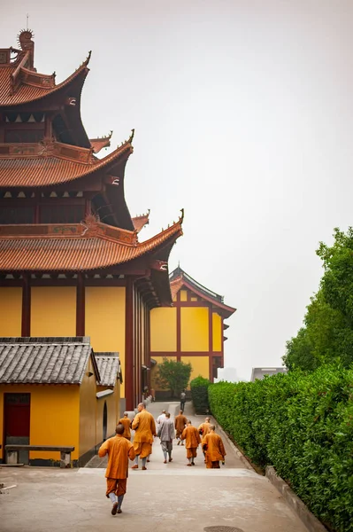 Siedmiu mnichów w pomarańczowe szaty spaceru w świątyni Lufeng — Zdjęcie stockowe