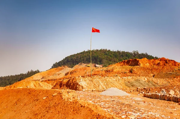 Classical rural chinese landscape with red soil nd Chinese flag on stcik