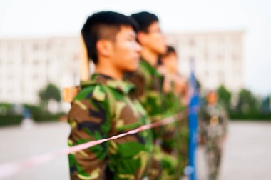 Chinese freshmen college students are standing stand still in line during military training at school clipart