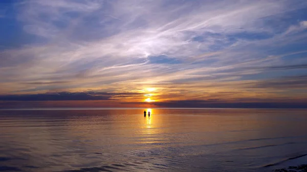 Отражении Солнца Море Видны Силуэты Людей Время Великолепного Цветного Заката — стоковое фото