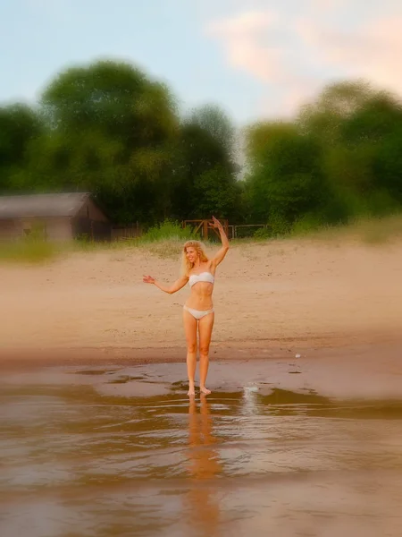 Zomer vakantie, vakantie en strand concept-blond meisje in witte bikini poseren op het strand. Achtergrond vervagen. — Stockfoto