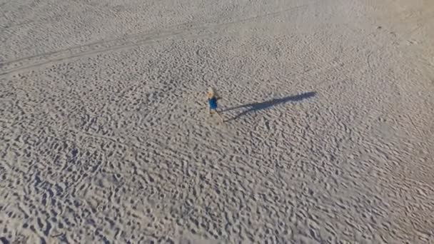 Uma Loira Vestido Azul Corre Longo Areia Amarela Uma Praia — Vídeo de Stock