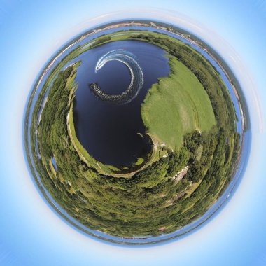 Küresel 360 derecelik bir panoramanın küçük gezegen dönüşümü. Yeşil orman ve gölün küresel soyut hava görüntüsü ve bottan köpüklü bir iz. Uzayın eğriliği.