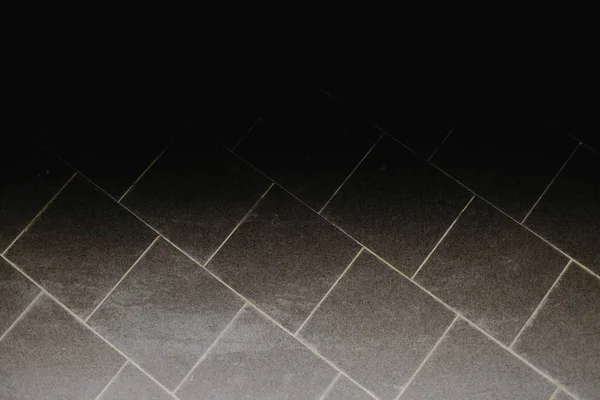 Dark rough tiles floor at night