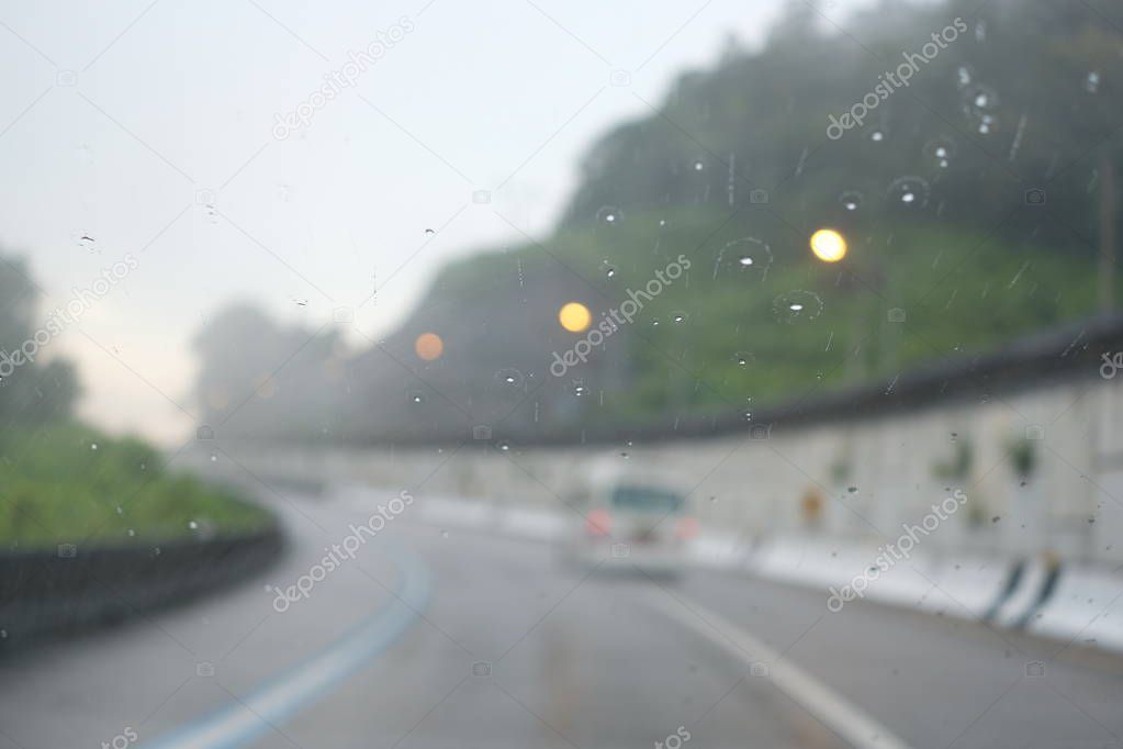 Blurred road on mountain with raindrop on foreground