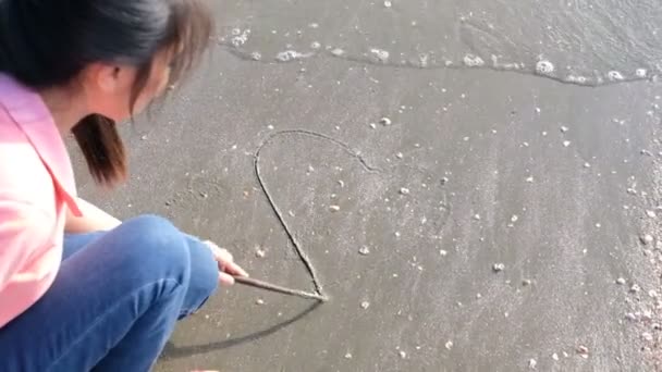 女孩画心脏形状在海滩 — 图库视频影像