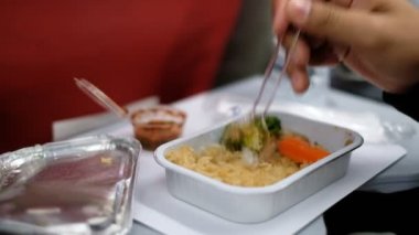 Hava uçağında küçük türbülans görünürken yemek yeen yolcu