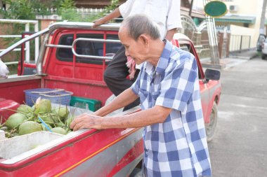 Old man choosing and buying coconuts on pickup truck clipart