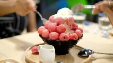 İnsanlar kafe ve restoranda bingsu karpuz topları yemekten hoşlanıyorlar.