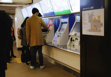 Tokyo, Japonya - 23 Kasım 2018: Yolcular bir sonraki metro istasyonuna gitmeden önce eski büfe makinelerinden bilet aldılar