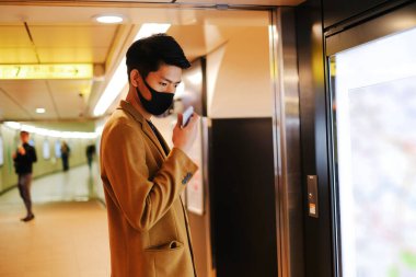 Asyalı adam haritadaki metro istasyonunu aramak ve yön sormak için ses kaydı gönderdi.