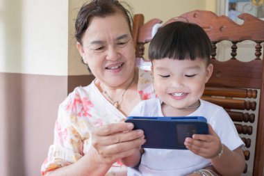 Torun, büyükannesiyle akıllı telefonda vakit geçiriyor. Ev konseptinde kal