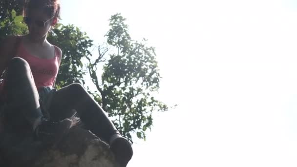 Junge Bergsteigerinnen versuchen, einen Weg hinunter auf die Klippe zu finden (thailändische Sprache auf T-Shirt ist i 'm climbing ) — Stockvideo