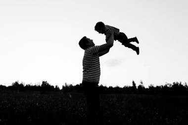 Baba ve oğul günbatımı anda parkta oynamak. Mutlu aile açık eğleniyor