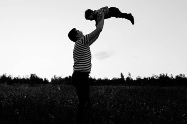 Gün batımında çiçek alandaki küçük oğluyla oynamaya baba. Adam atmak kadar küçük çocuk