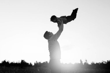 Baba ve oğul alanında günbatımı anda oynamak. İnsanlar sahada eğleniyor. Dostu aile ve yaz tatil kavramı