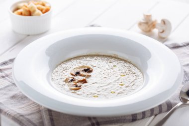 Beyaz tabak yan görünümünde kremalı mantar çorbası