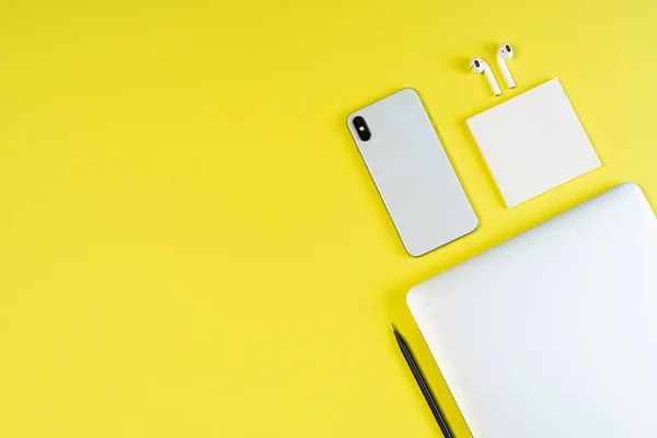 Наушники для ноутбука телефон желтый минимальный верхний макет — стоковое фото