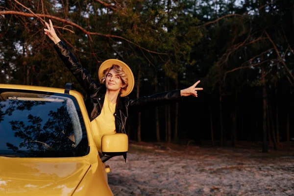 Mulher sorridente caucasiana inclinada para fora da janela do carro — Fotografia de Stock