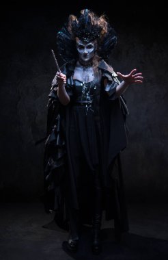 Cadı kostümlü kadın stüdyoda poz veriyor.