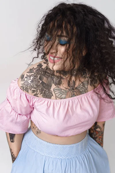 Szczęśliwa Atrakcyjna Kobieta Pięknymi Tatuażami Pastelowych Ubraniach Stwarzających Światło Studio — Zdjęcie stockowe