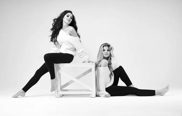 Twee Mooie Modellen Zwart Wit Kleding Poseren Met Tafel Geïsoleerd — Stockfoto
