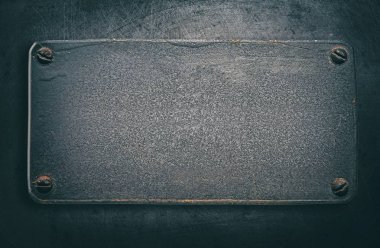 Çelik arka plan üzerinde perçin ile metal plaka