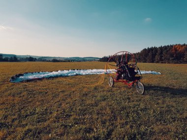 Motorlu yamaç paraşütü araç ile uçan için hazırlanan yeşil çim sahada