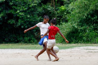 Maroantsetra, Madagaskar - 23 Kasım 2016: Mutlu Madagaskarlı çocuk, erkek ve kız çıplak ayak ile Madagaskar'daki Masoala yağmur ormanı yakınlarında onun köy arkasında futbol oynamak.