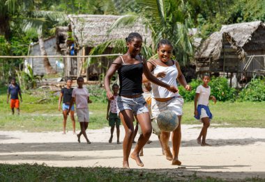 Maroantsetra, Madagaskar - 23 Kasım 2016: Mutlu Madagaskarlı çocuk, erkek ve kız çıplak ayak ile Madagaskar'daki Masoala yağmur ormanı yakınlarında onun köy arkasında futbol oynamak.