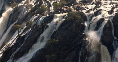Kuzey Namibya 'daki Kunene Nehri' ndeki güzel Ruacana Şelalesi ve Güney Angola, Afrika vahşi doğası, Şelale yağmur mevsiminden sonra suyla doludur..