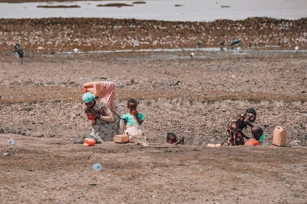 エチオピア オロムニアのコカ湖2019年5月11日 アフリカの女性は 背中に水たまりから泥だらけの雨の水を運んでいます 水の不足はアフリカ全体の問題です — ストック写真