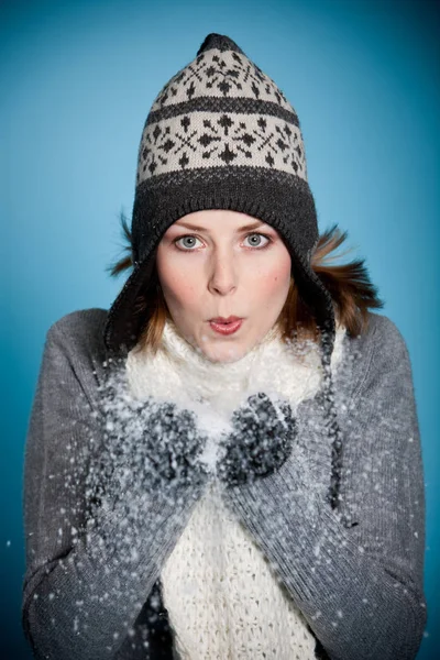 彼女の手から雪を吹いてかわいい若い女の子 — ストック写真