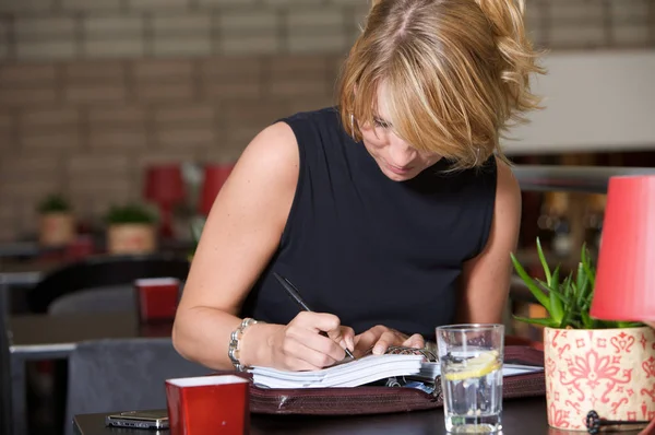 Hübsche Blonde Frau Schreibt Ihr Notizbuch Sitzt Einem Restaurant — Stockfoto