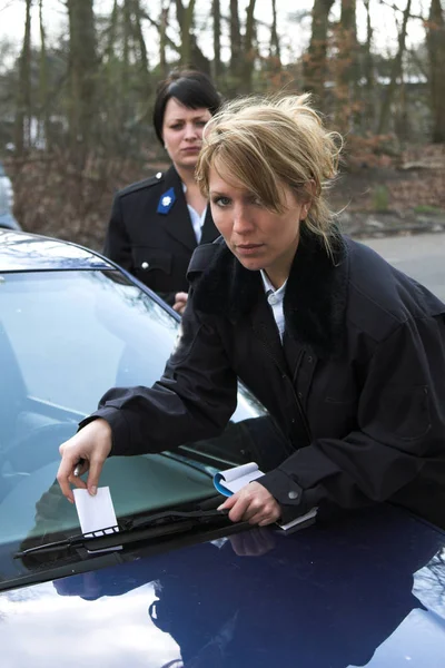 Vrouwelijke Politieagent Zetten Een Parkeerticket Onder Windscreenwiper — Stockfoto