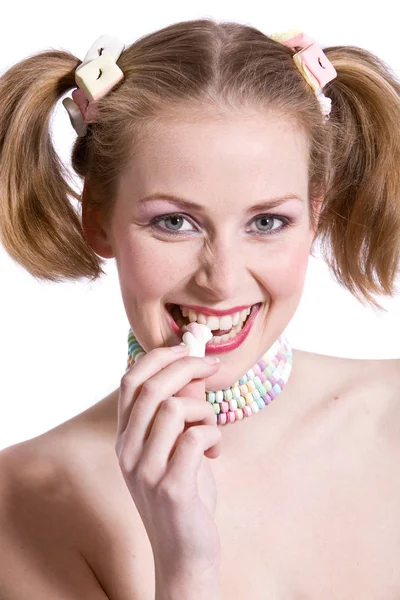 かわいいブロンドの女の子のポニーテールと八重歯がキャンディをかむ — Stockfoto